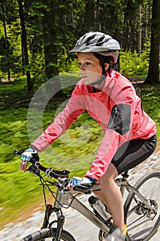 Woman mountain biking in forest motion blur