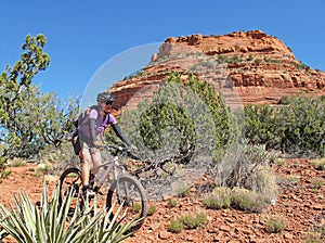 Woman mountain biking in the red rocks, Sedona, USA