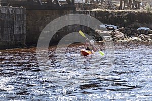 A woman on a mountain river is engaged in rafting. A girl is kayaking down a mountain river.girl in a kayak, side view