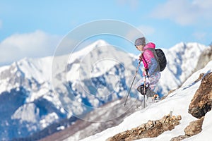 Woman mountaineer downhill with crampons on snowy slope