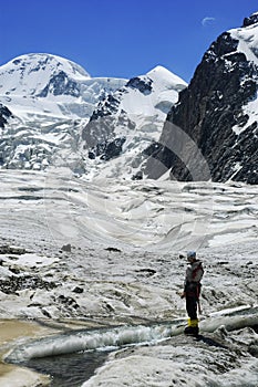 Woman mountaineer near glacial stream.