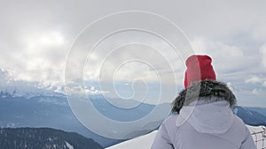 Woman in the mountains looking at beautiful view in ski resort