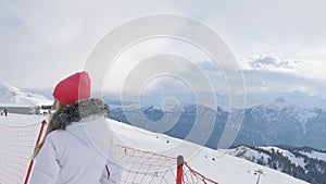 Woman in the mountains looking at beautiful view in ski resort