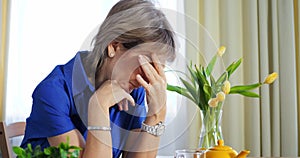 Woman mourning loss, showcasing loneliness, sadness. Elderly loneliness depicted in serene home setting, solitude