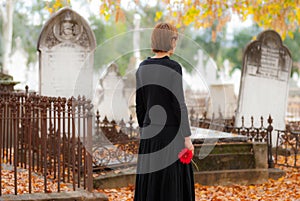 Woman in Mourning Walking in Cemetery