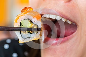 Woman mouth eat sushi