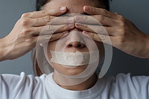 Woman with mouth sealed in adhesive tape. Free of speech, freedom of press, Human rights, Protest dictatorship, democracy, liberty photo