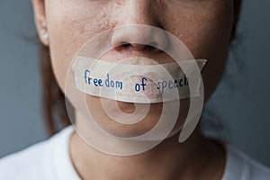 Woman with mouth sealed in adhesive tape with Freedom  of Speech message., freedom of press, Human rights, Protest dictatorship,