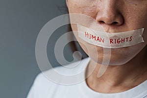 Woman with mouth sealed in adhesive tape with Human rights message. Free of speech, freedom of press, Protest dictatorship,