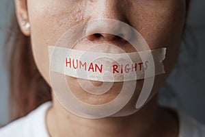 Woman with mouth sealed in adhesive tape with Human rights message. Free of speech, freedom of press, Protest dictatorship,