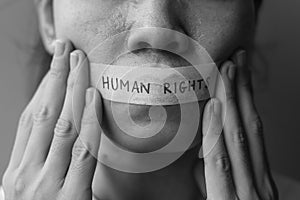 Woman with mouth sealed in adhesive tape with Human rights message. Free of speech, freedom of press, Protest dictatorship, photo