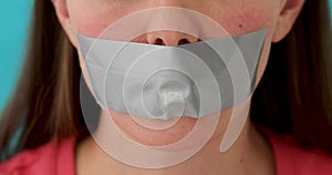 Woman with mouth sealed with attached sticky tape