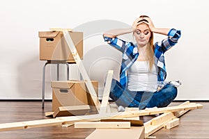 Woman moving into apartment assembly furniture.