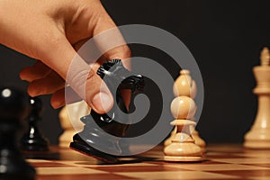 Woman moving chess piece on board, closeup