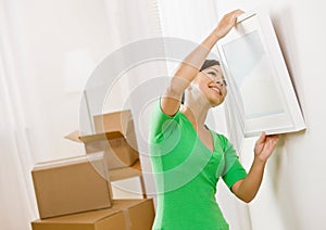 Woman moving into new home hanging picture