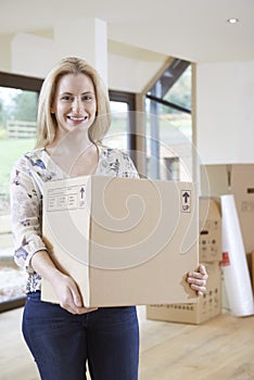 Woman Moving Into New Home With Packing Box