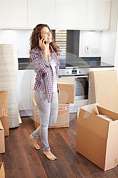 Woman Moving Into New Home Talking On Mobile Phone