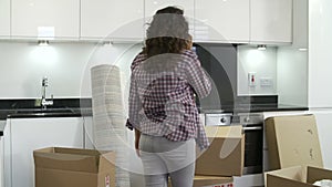 Woman Moving Into New Home Talking On Mobile Phone