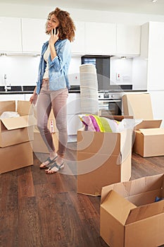 Woman Moving Into New Home Talking On Mobile Phone