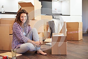 Woman Moving Into New Home And Unpacking Boxes