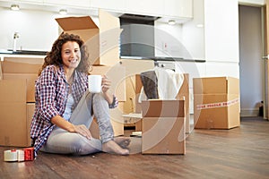 Woman Moving Into New Home And Unpacking Boxes