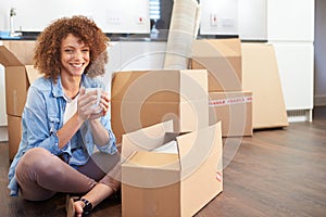 Woman Moving Into New Home And Unpacking Boxes