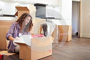 Woman Moving Into New Home And Unpacking Boxes