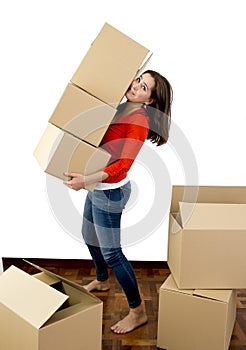 Woman moving in a new house carrying pile of cardboard boxes