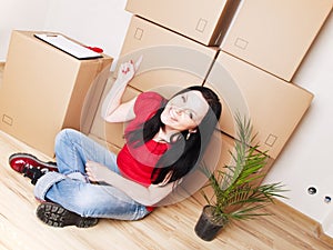 Woman moving to new house and pointing carton