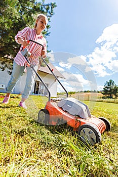 Woman mowing green grass