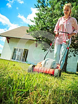 Woman mowing green grass