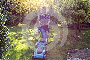 Woman mowing lawn in garden