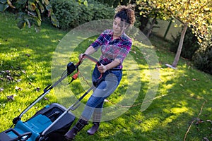 Woman mowing lawn in garden