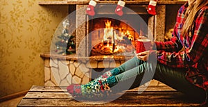 Woman with a mug by the fireplace. Young attractive woman sittin