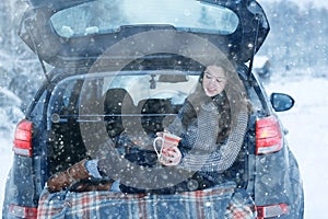 Woman with mug of hot drink in winter forest