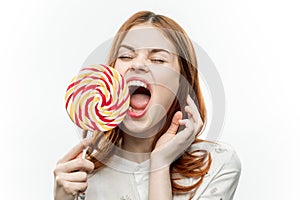 woman with multicolored lollipop near face cropped view of sweets emotion with open mouth