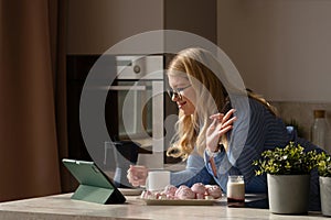 Woman multitasking with tablet and breakfast