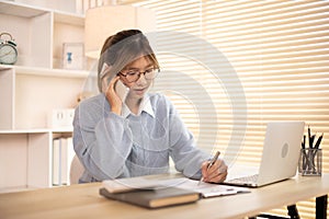 Woman Multitasking: Take note, Talking on Phone at Home Office