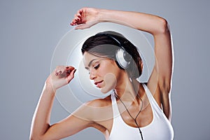Woman, music and dancing fun with headphones, relax and audio with song streaming and casual fashion in studio. Samba
