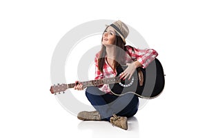 woman musician with guitar sitting on floor.