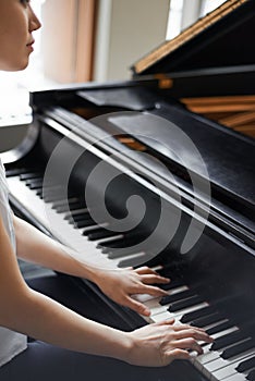 Woman, musician and playing with piano for music, melody or sound with acoustic instrument at home. Female person