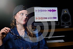 Woman musician sitting in a recording Studio. Portrait of a girl on the recording of a song in the Studio. The singer in place of