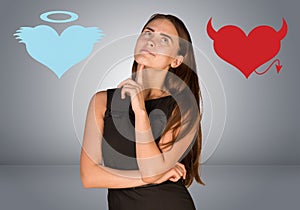Woman musing between angel and devil hearts photo