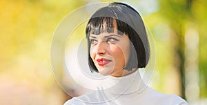 Woman mysterious with red lips makeup face defocused background close up. Makeup bright accent on lips. Red lipstick