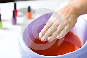 Woman in nail salon having paraffin bath