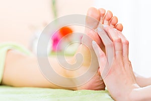 Woman in nail salon receiving foot massage