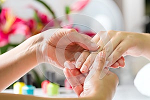 Woman in nail salon receiving hand massage