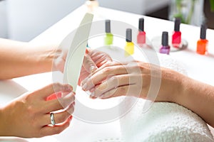 Woman in nail salon receiving manicure