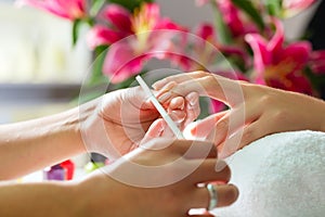 Woman in nail salon receiving manicure