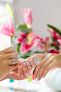 Woman in nail salon receiving manicure